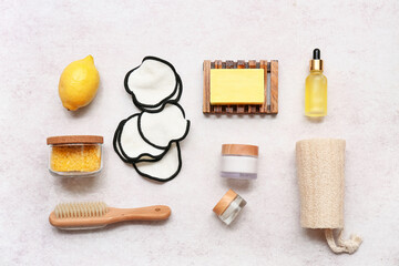 Cotton pads, lemon and bath supplies on light background