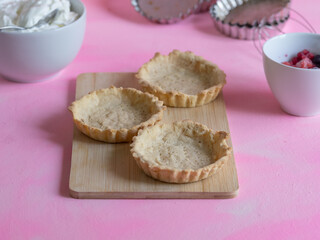 Artisan tartlets together with the ingredients prepared to cook a dessert of red fruits.