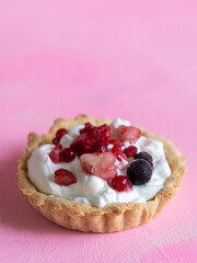 Homemade and healthy yogurt and red fruit tartlet isolated on pastel pink background