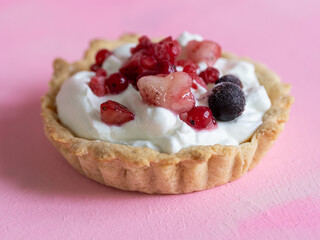 Homemade and healthy yogurt and red fruit tartlet isolated on pastel pink background