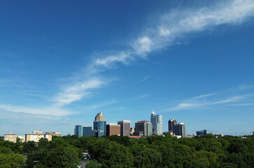 Aerial view of the downtown Raleigh skyline with trees in the foreground