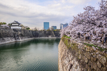 Osaka, Japan - April 7, 2024: A majestic view of Osaka Castles stone walls, turret and moat,...