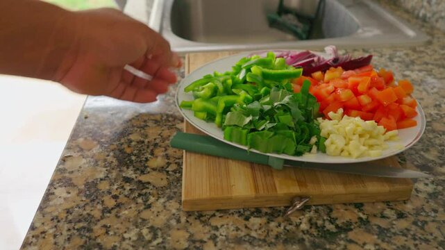 A green knife is on a wooden cutting board