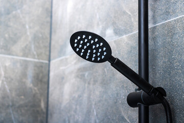 A black shower head that features white dots decorating its surface