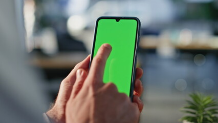 Businessman using chromakey smartphone making online order at workplace closeup.