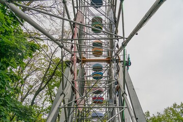 Carousel in natural setting, empty seats, soft lighting, overcast sky, traditional design