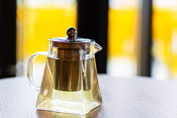 A beautifully crafted glass teapot is sitting on a wooden table