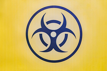Hazard symbol on a yellow gradient background, dark blue, light blue, and white zones, central atom...