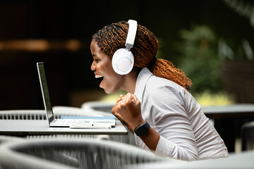Beautiful black female freelancer working on laptop computer in cafe bar.