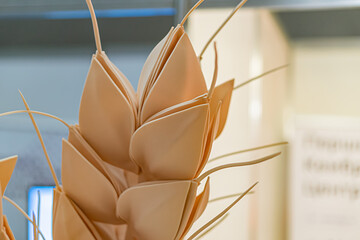 Decorative bamboo-like corn ear sculpture on interior wall background, intricately layered with textured kernels Soft lighting without shadows