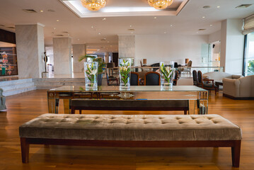Interior of a hotel lobby in Cyprus featuring polished wooden flooring, chandeliers, a mirrored...