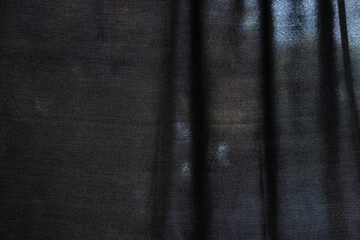 Black translucent curtain with street light in the background