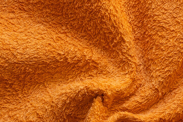 Orange terry towel close up, soft fabric texture with loops, cotton material