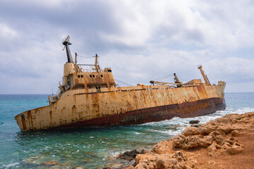 The Edro III shipwreck rests near the rocky coastline of Paphos, Cyprus, surrounded by turquoise...
