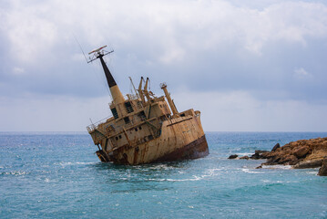 The Edro III shipwreck rests tilted near the rocky coast of Cyprus, surrounded by calm turquoise...