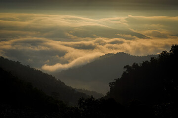 Morning light in the mountains. Fog in the valley. Sunlight entering the valley and on the mountains. Beautiful summer morning