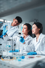 Fototapeta premium A female scientist in a white lab coat and blue gloves closely examines a petri dish with visible mold cultures, showcasing focus and expertise in microbiological analysis and lab research.