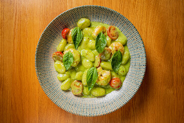 A delightful plate of gnocchi features fresh basil leaves and ripe cherry tomatoes, served warmly