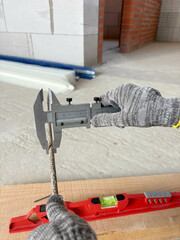 Measuring the diameter of reinforcement using a caliper. Work process at a construction site....