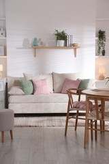 Stylish dining table with chairs and comfortable sofa in room. Interior design