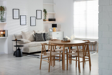 Table, chairs and comfortable sofa indoors. Interior design