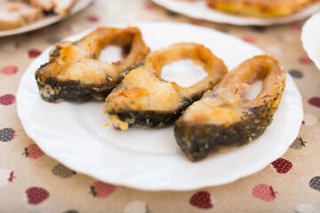 Three pieces of fried carp on a white plate