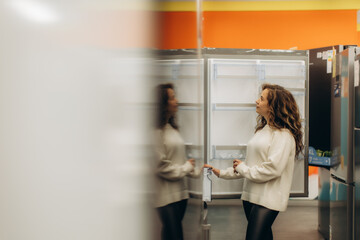 Young Woman Browsing Refrigerators in a Modern Appliance Store