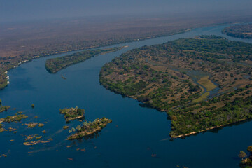 Aerial view of lush island and winding river in Zambia, showcasing natural beauty, tropical...