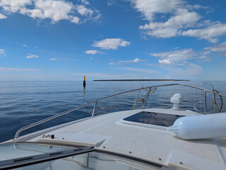 A summer boat trip on a motorboat across the calm Baltic Sea. A picturesque view from the boat of Naissaar island on the horizon and a navigational buoy