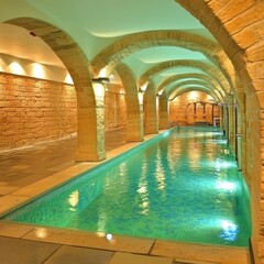 Luxurious indoor pool with arched stone walls.  Tranquil, elegant, and spacious