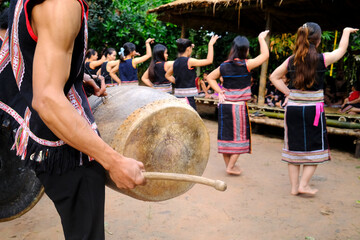 Traditional ceremony in a Bahnar ethnic village in the Kontum region. Young people in traditional clothing playing percussion instruments. Kontum. Vietnam.