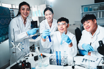 A team of scientists in a modern lab analyzing test tubes with blue liquids. They collaborate,...