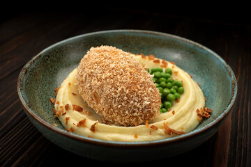 Traditional Kyiv cutlet with mashed potatoes and green peas