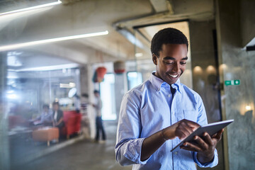 Confident young man working on a digital tablet in a modern office setting