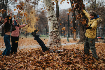 A group of people celebrates fall by tossing leaves in a park, showcasing their happiness and the beauty of autumn.