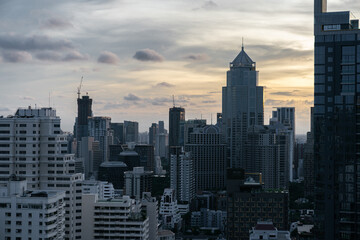 Fototapeta premium Modern Urban Skyline at Sunset with High-Rise Buildings and Cloudy Sky