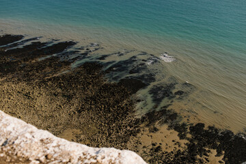 Low tide on a sandy and rocky beach. Top view from the cliff. Seven Sisters, UK