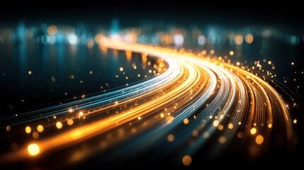 Light trails curve smoothly on a dark road, creating dynamic streaks of orange and blue illumination against a blurred cityscape background.
