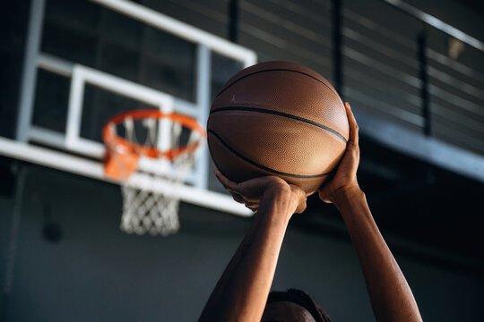 Close up view of man's hands that are about to throw basketball ball into the hoop