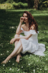 Obraz premium A young woman relaxing in nature, lying on the grass, soft focus trendy image