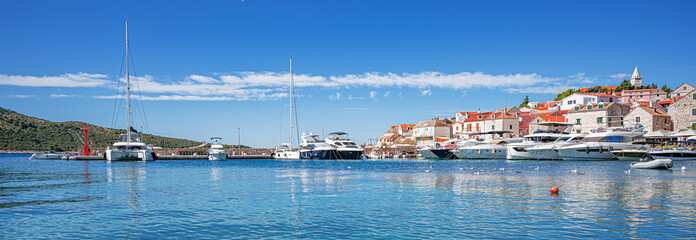 A stunning coastal town of Primosten in Croatia features traditional stone houses with red roofs...