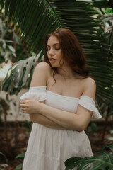 Woman in a White Dress is walking in a park, soft-focus trendy image. 