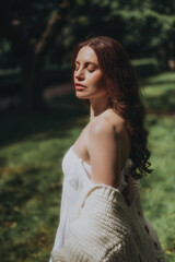 Naklejka premium Woman in a White Dress is walking in a park, soft-focus trendy image. 