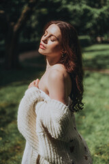 Naklejka premium Woman in a White Dress is walking in a park, soft-focus trendy image. 