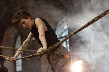 A woman in a boxing gym, portrait by the ropes, ready to fight, cinematic style photo, soft...