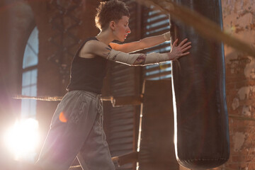 Short-haired fighter in boxing ring, cinematic rest moment between intense rounds.
