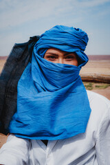Close-up of a woman wearing a blue turban in the desert wind, Morocco