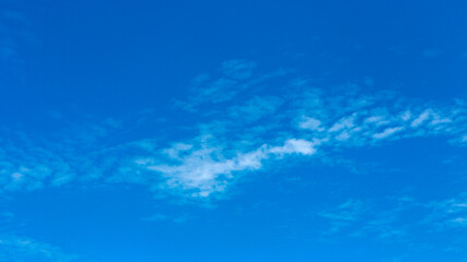 Bright blue sky with sparse, white clouds, perfect for backgrounds, serene outdoor themes, or as a natural overlay for various design projects