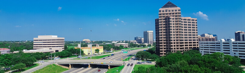 Panorama aerial view multilevel parking garage, glass office building, high-rise towers in Las Colinas, Irving, master planned mixed use development commercial properties, residential houses, golf