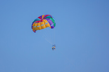 tourists parasailing on a sea seen against the clear blue sky